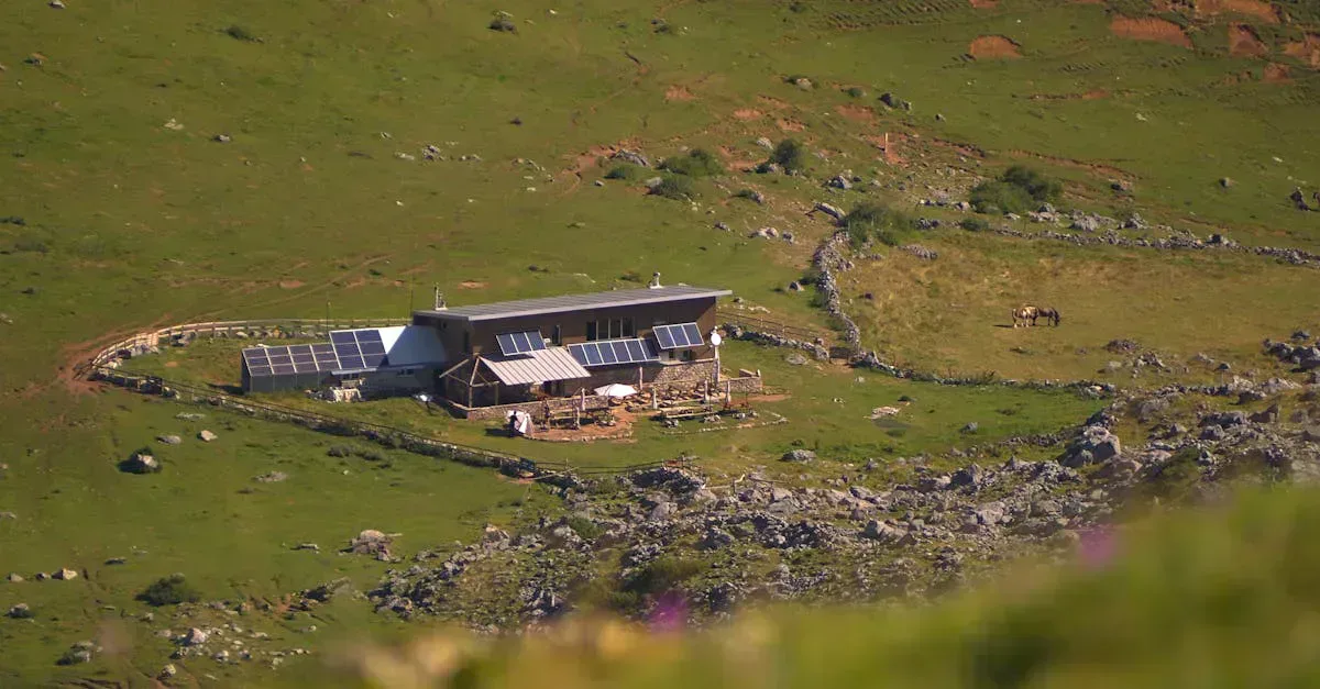Off-grid stone cabin with rooftop and ground-mounted solar panels in a green mountain valley