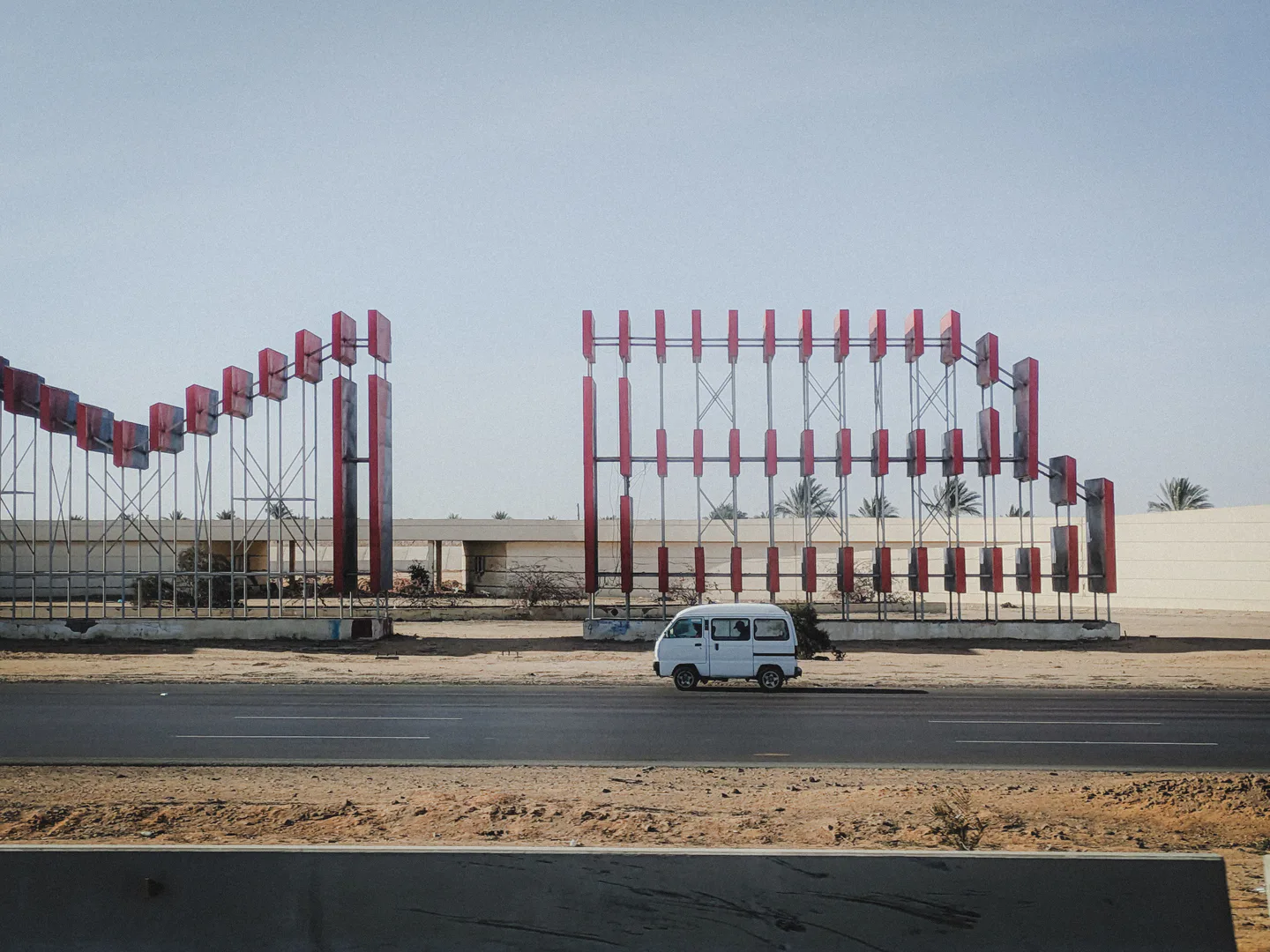 A van driving down an empty desert highway under a clear sky